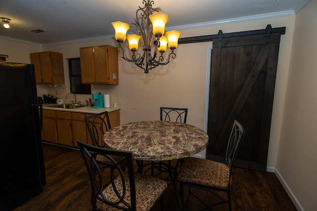 dining room featuring sink, an inviting chandelier, a barn door, dark hardwood / wood-style floors, and ornamental molding