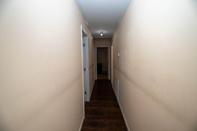 hallway with dark hardwood / wood-style floors and ornamental molding