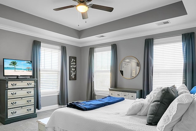 carpeted bedroom featuring a tray ceiling, ceiling fan, and ornamental molding