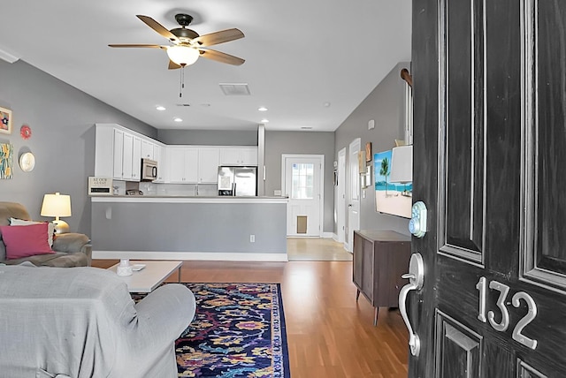 living room featuring hardwood / wood-style flooring and ceiling fan