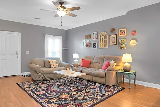 living room featuring ceiling fan, ornamental molding, and hardwood / wood-style flooring