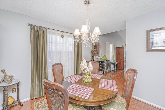 dining room featuring a textured ceiling, a chandelier, and hardwood / wood-style flooring