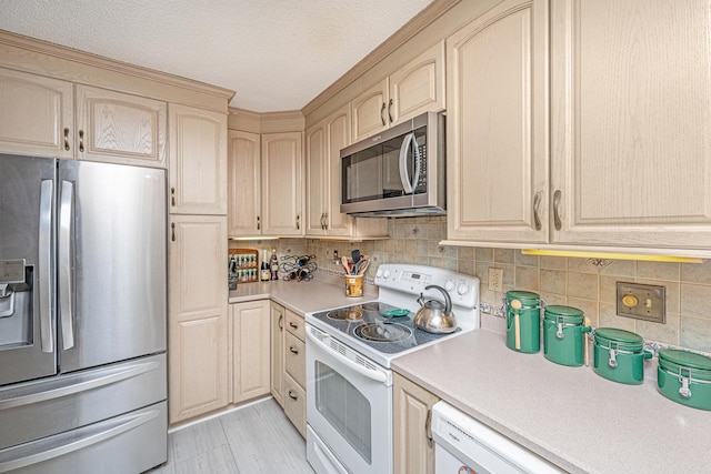 kitchen featuring light brown cabinets, appliances with stainless steel finishes, a textured ceiling, and tasteful backsplash