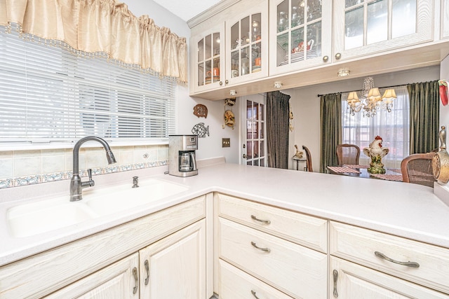 kitchen featuring an inviting chandelier, a healthy amount of sunlight, light brown cabinetry, and sink