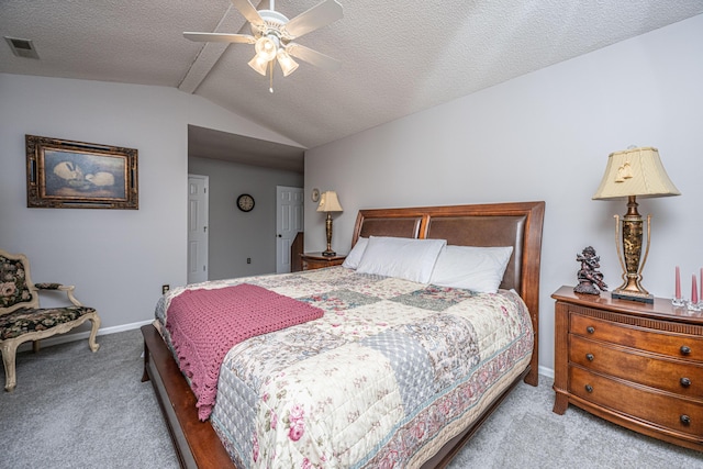 bedroom featuring ceiling fan, vaulted ceiling, light carpet, and a textured ceiling