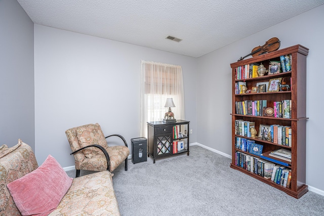 living area with light colored carpet and a textured ceiling