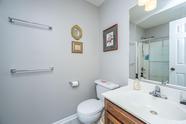 bathroom featuring toilet, a textured ceiling, a shower with shower door, and vanity