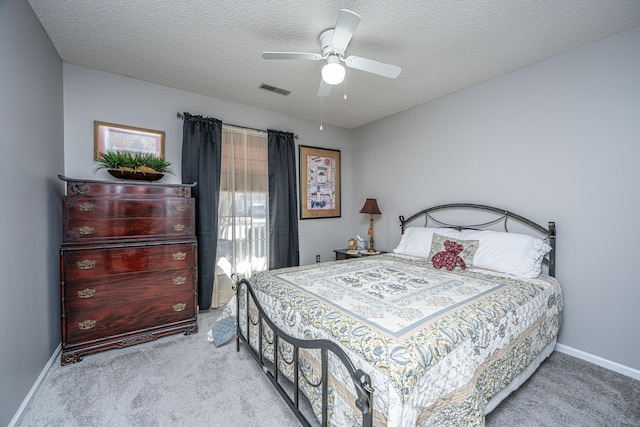 carpeted bedroom with ceiling fan and a textured ceiling