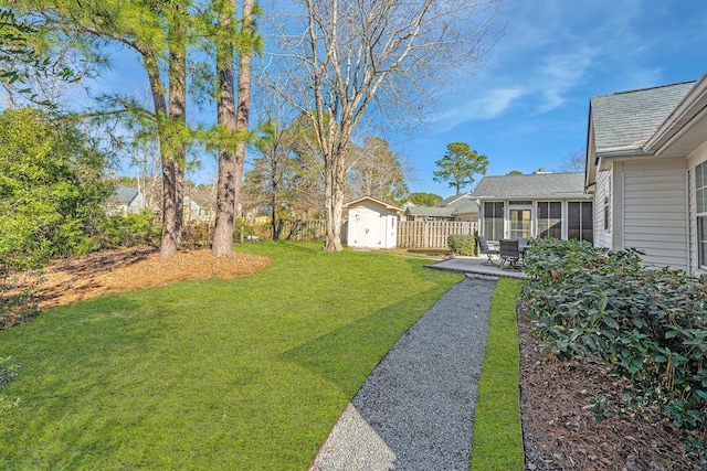 view of yard featuring a storage shed, a patio area, and a sunroom