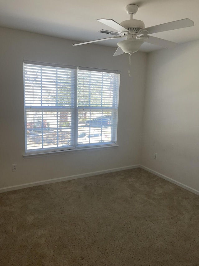 unfurnished room featuring visible vents, ceiling fan, a wealth of natural light, and baseboards