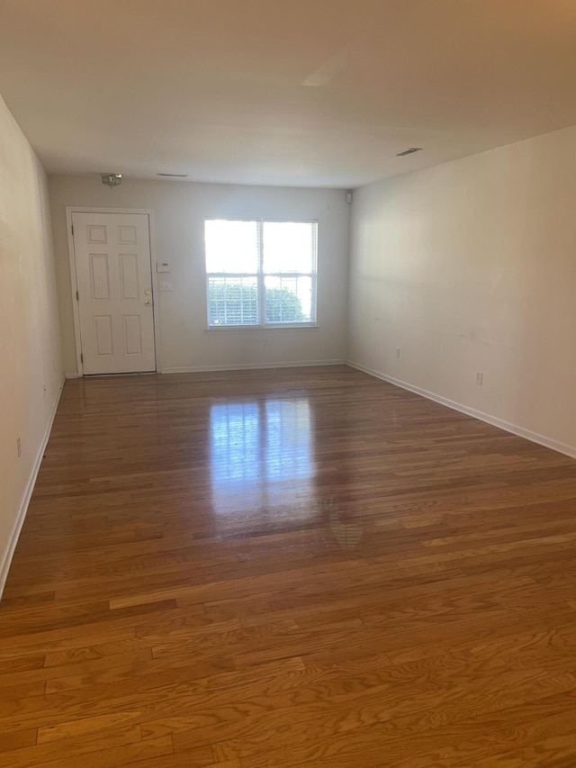 empty room with baseboards and wood finished floors