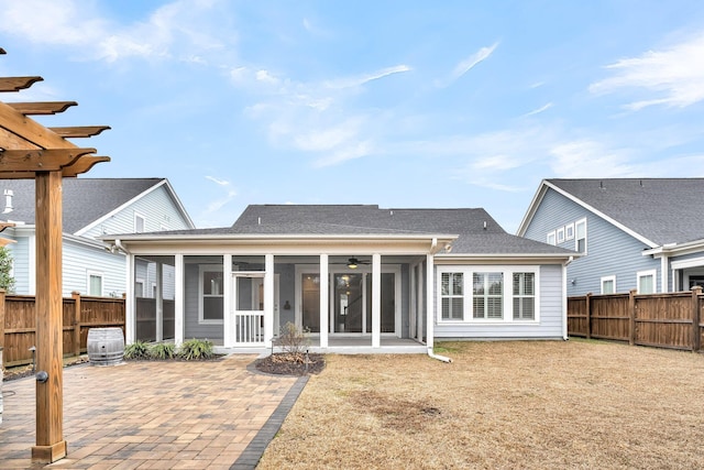 back of house featuring a sunroom, a yard, and a patio