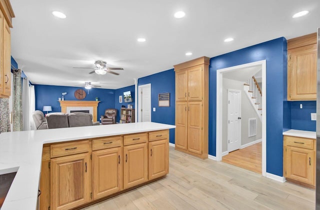 kitchen featuring light brown cabinets, light hardwood / wood-style floors, and ceiling fan