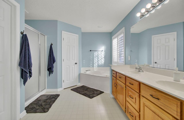 bathroom featuring a textured ceiling, vanity, and separate shower and tub