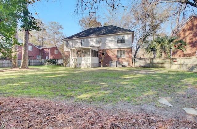 rear view of property with a yard and a sunroom