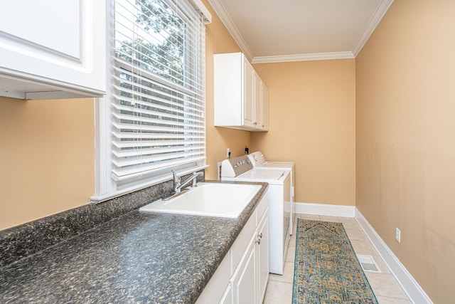 washroom with sink, crown molding, light tile patterned floors, cabinets, and separate washer and dryer