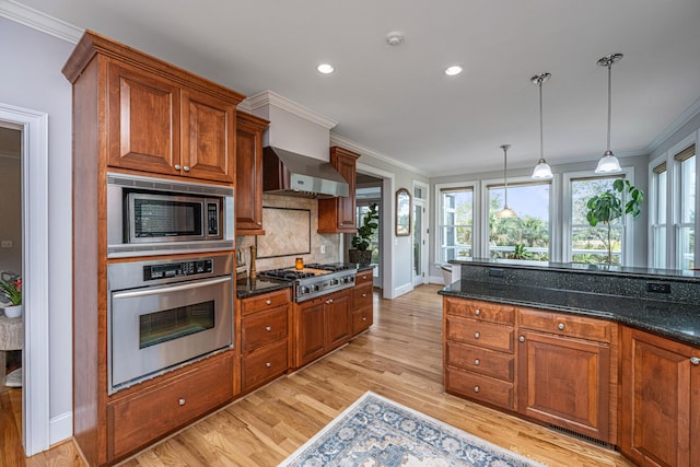 kitchen with appliances with stainless steel finishes, decorative light fixtures, dark stone countertops, decorative backsplash, and ornamental molding