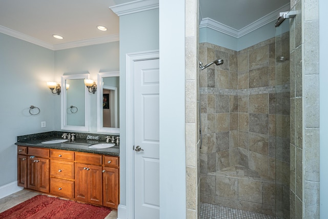 bathroom with crown molding, vanity, tile patterned flooring, and a tile shower