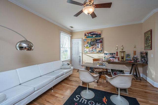 home office with ornamental molding, ceiling fan, and light wood-type flooring