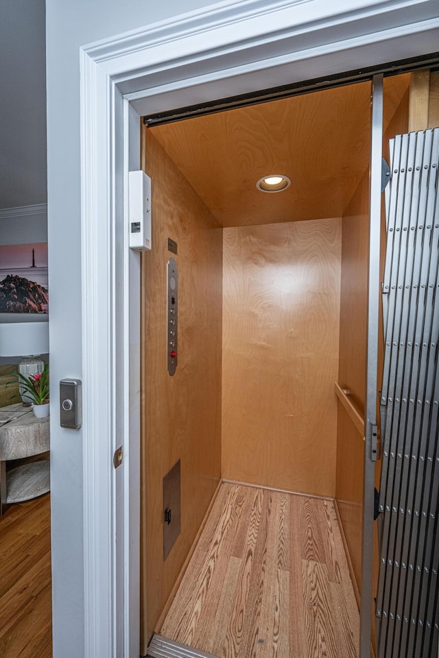 room details with hardwood / wood-style flooring and elevator