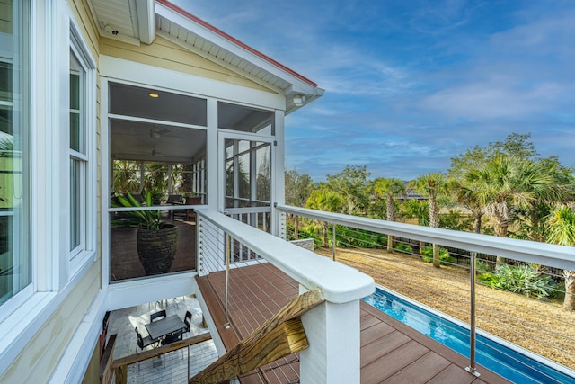 wooden terrace featuring a swimming pool and a sunroom