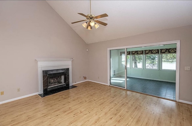 unfurnished living room with a premium fireplace, ceiling fan, high vaulted ceiling, and light hardwood / wood-style floors