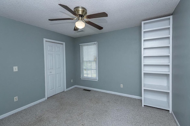 unfurnished bedroom with ceiling fan, light colored carpet, and a textured ceiling