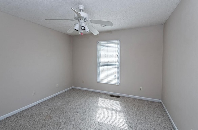 carpeted spare room with a textured ceiling and ceiling fan