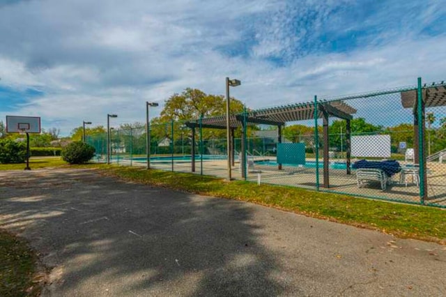 exterior space featuring a pergola and basketball hoop