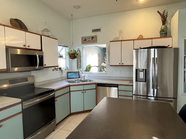 kitchen with white cabinets, sink, light tile patterned floors, and stainless steel appliances