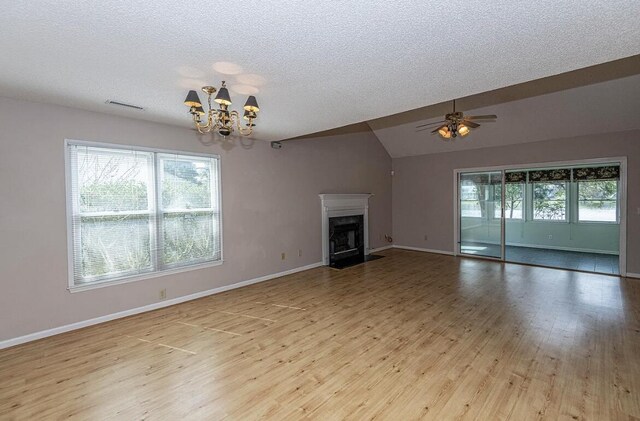 unfurnished living room with ceiling fan with notable chandelier, light wood-type flooring, a textured ceiling, and vaulted ceiling