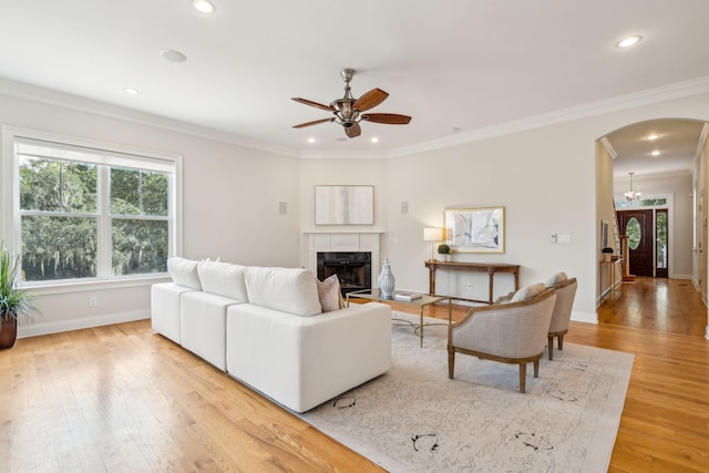 living room with hardwood / wood-style floors, ornamental molding, and a fireplace