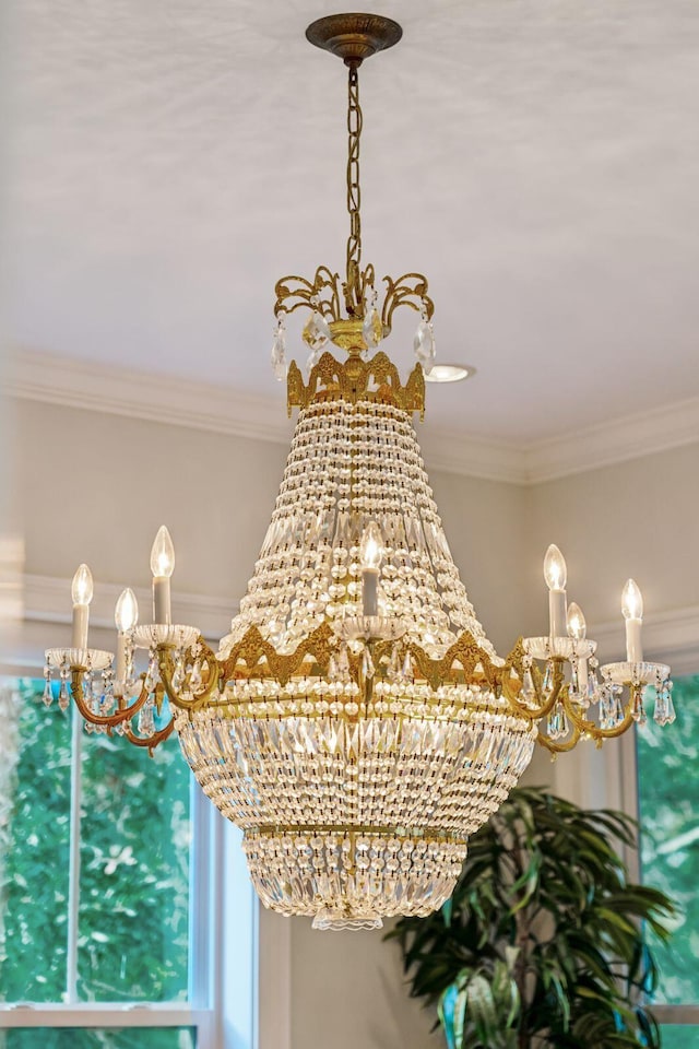 details with ornamental molding and an inviting chandelier