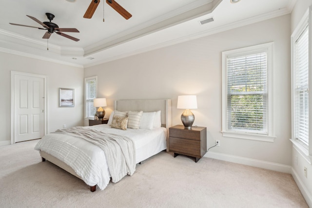 carpeted bedroom featuring ornamental molding, ceiling fan, and a tray ceiling