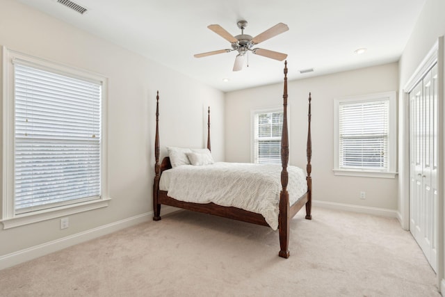 carpeted bedroom featuring ceiling fan and a closet