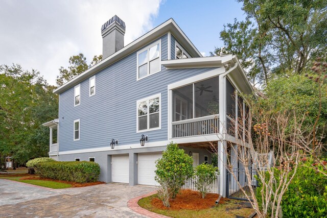 view of property exterior with a garage and a sunroom