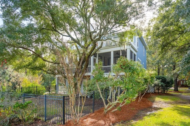 view of yard featuring a sunroom and a balcony