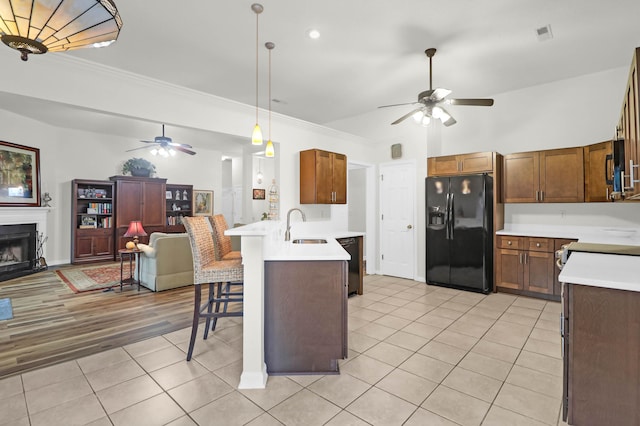 kitchen featuring open floor plan, a peninsula, black appliances, and ceiling fan