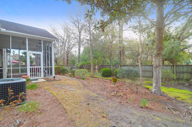 view of yard with a sunroom, fence, and central AC