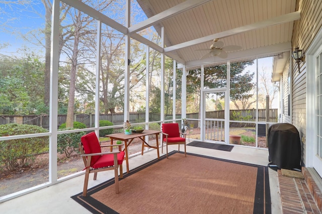 sunroom / solarium featuring vaulted ceiling with beams and a ceiling fan