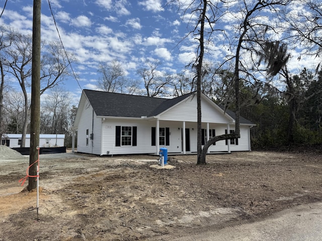 view of front of home featuring a shingled roof and covered porch