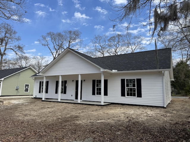 rear view of house featuring a porch and roof with shingles