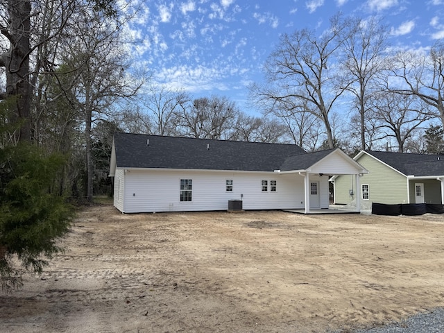 view of front of home with cooling unit and roof with shingles