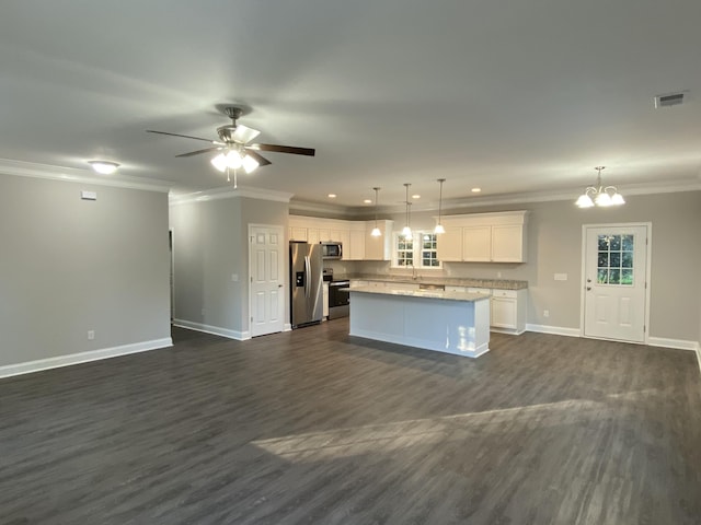 kitchen with visible vents, a kitchen island, appliances with stainless steel finishes, open floor plan, and ornamental molding