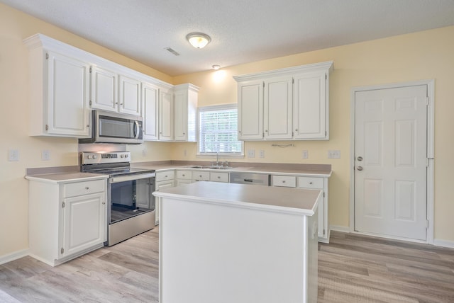 kitchen with visible vents, appliances with stainless steel finishes, white cabinets, and light countertops