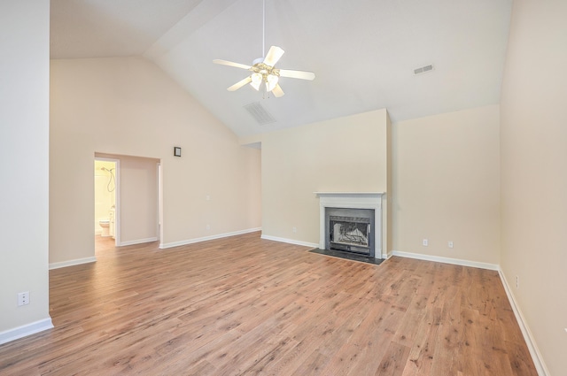 unfurnished living room featuring ceiling fan, high vaulted ceiling, light wood-style flooring, a fireplace with flush hearth, and baseboards