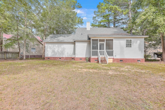 back of property featuring a sunroom, a chimney, crawl space, fence, and a yard