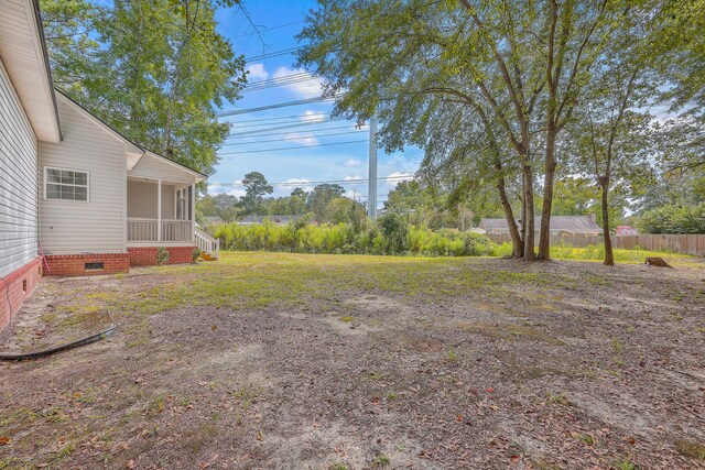 view of yard featuring fence and a sunroom
