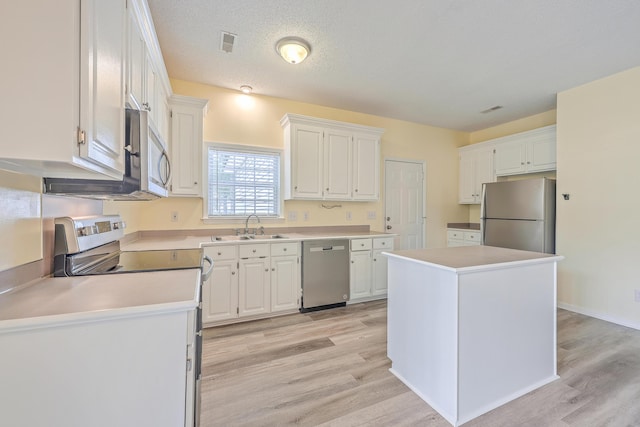 kitchen featuring stainless steel appliances, light wood-style floors, white cabinetry, and a sink