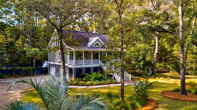 view of front of property with a porch, a front yard, and a garage